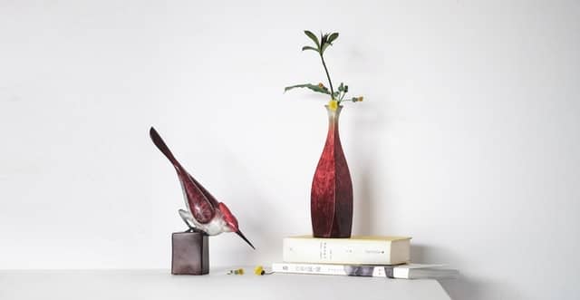 stylised vignette showing a bird, books & vase