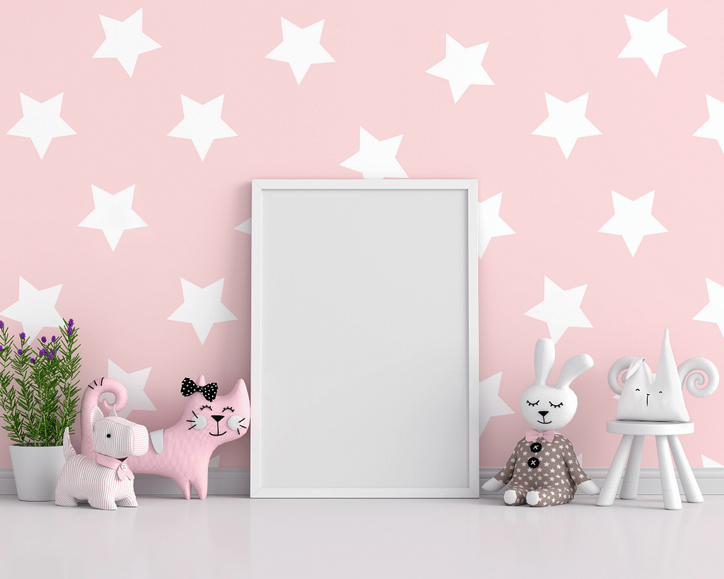 Pink wall with stencilled white stars and some toys