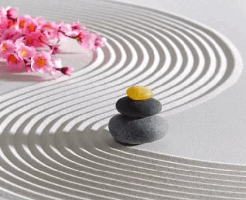 an example of zen garden with white sand, pebbles and flowers